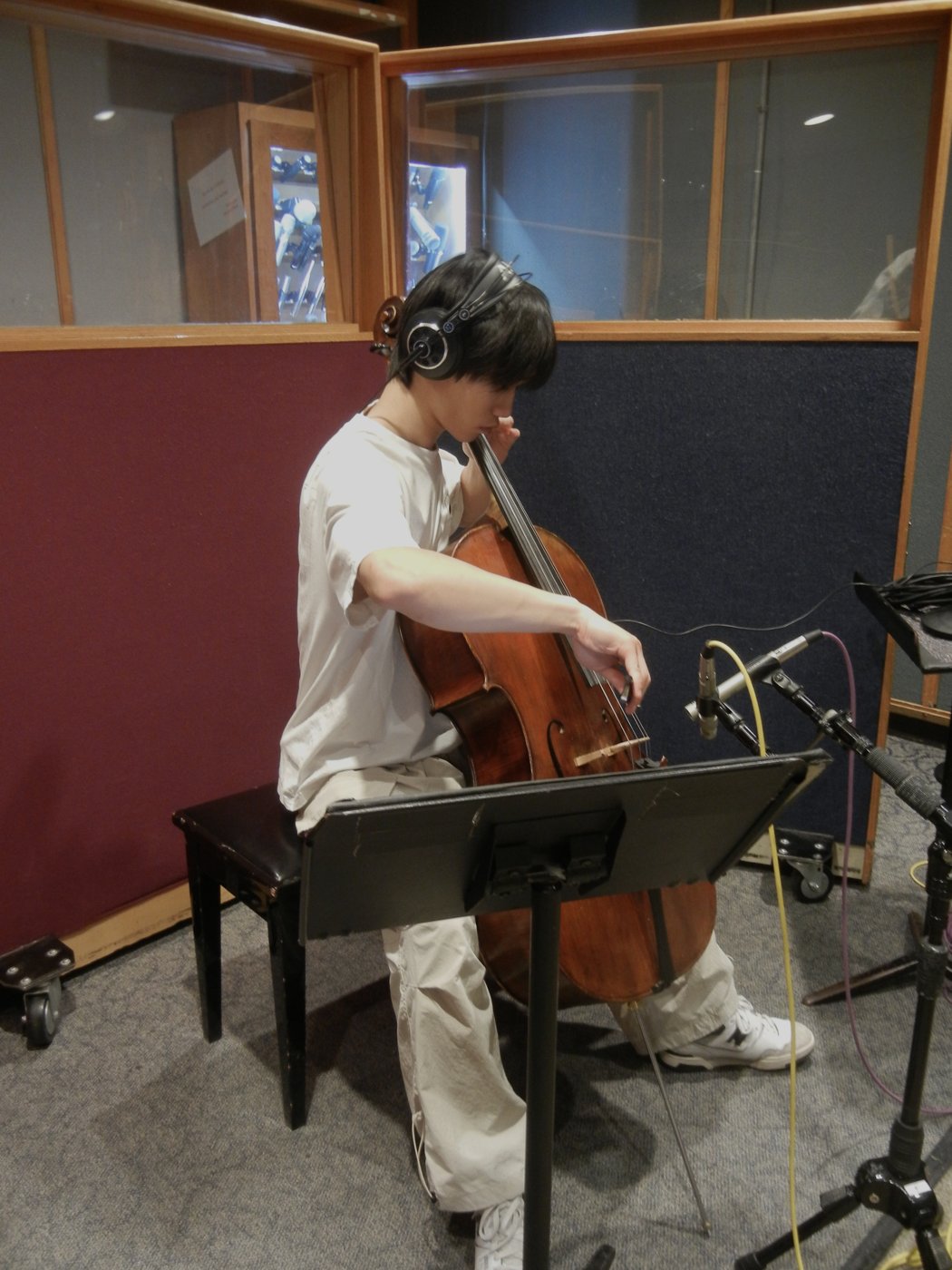 Matthew Kim playing cello in a recording studio